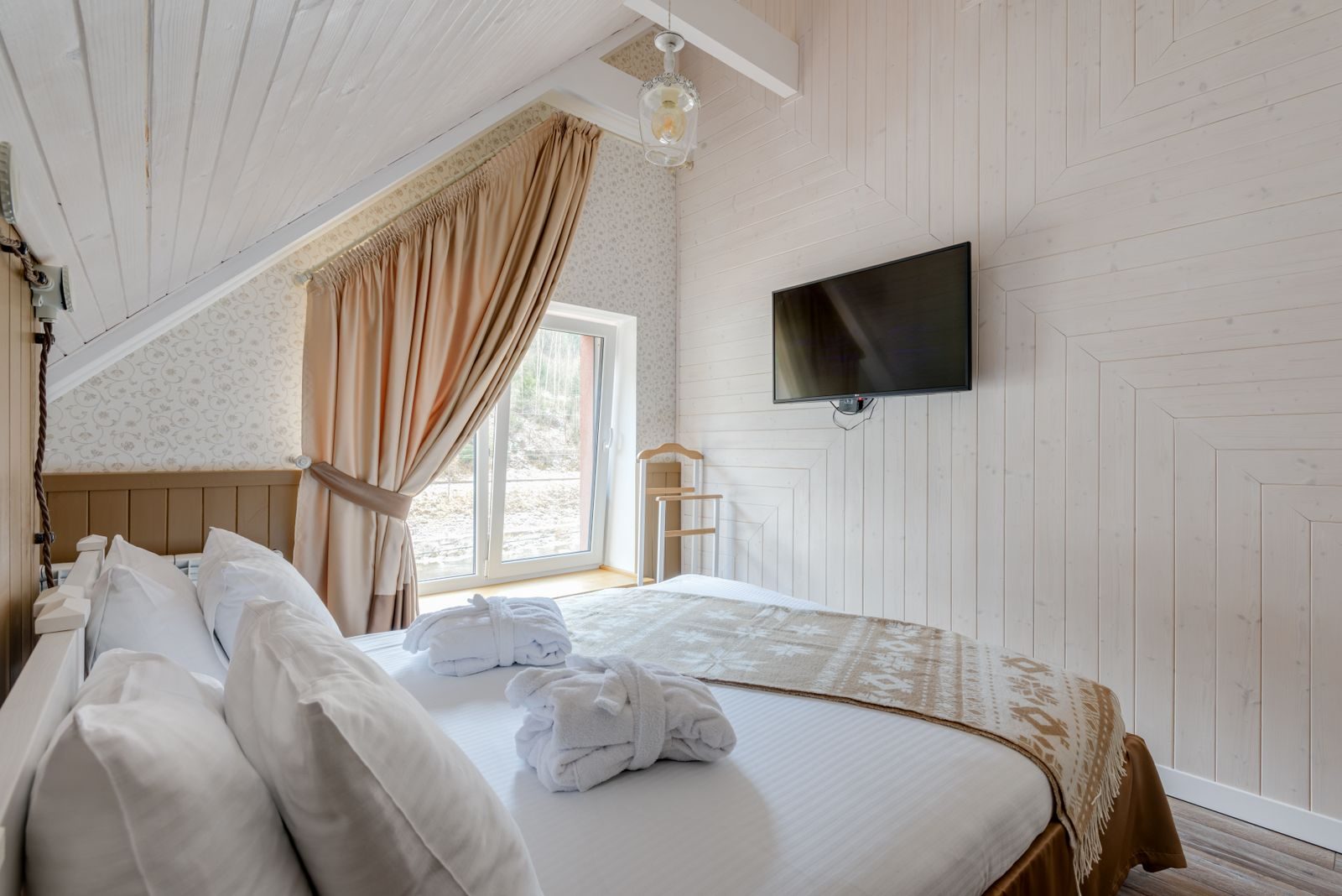Rideaux et voilages sur mesure dans une chambre d'hôtel élégante aux tons naturels