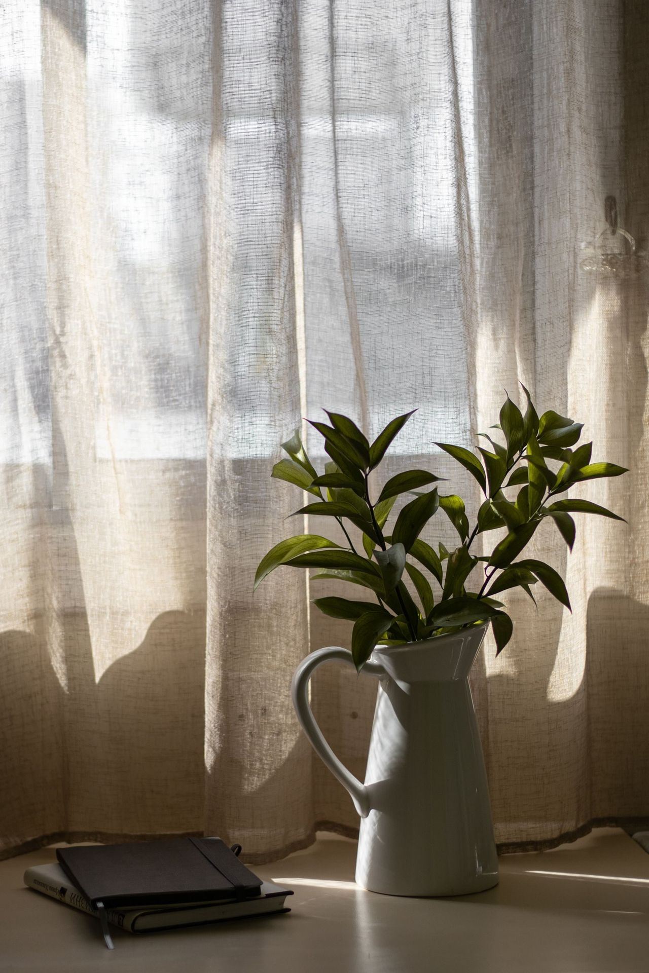 Voilage en lin filtrant la lumière naturelle près d'une fenêtre