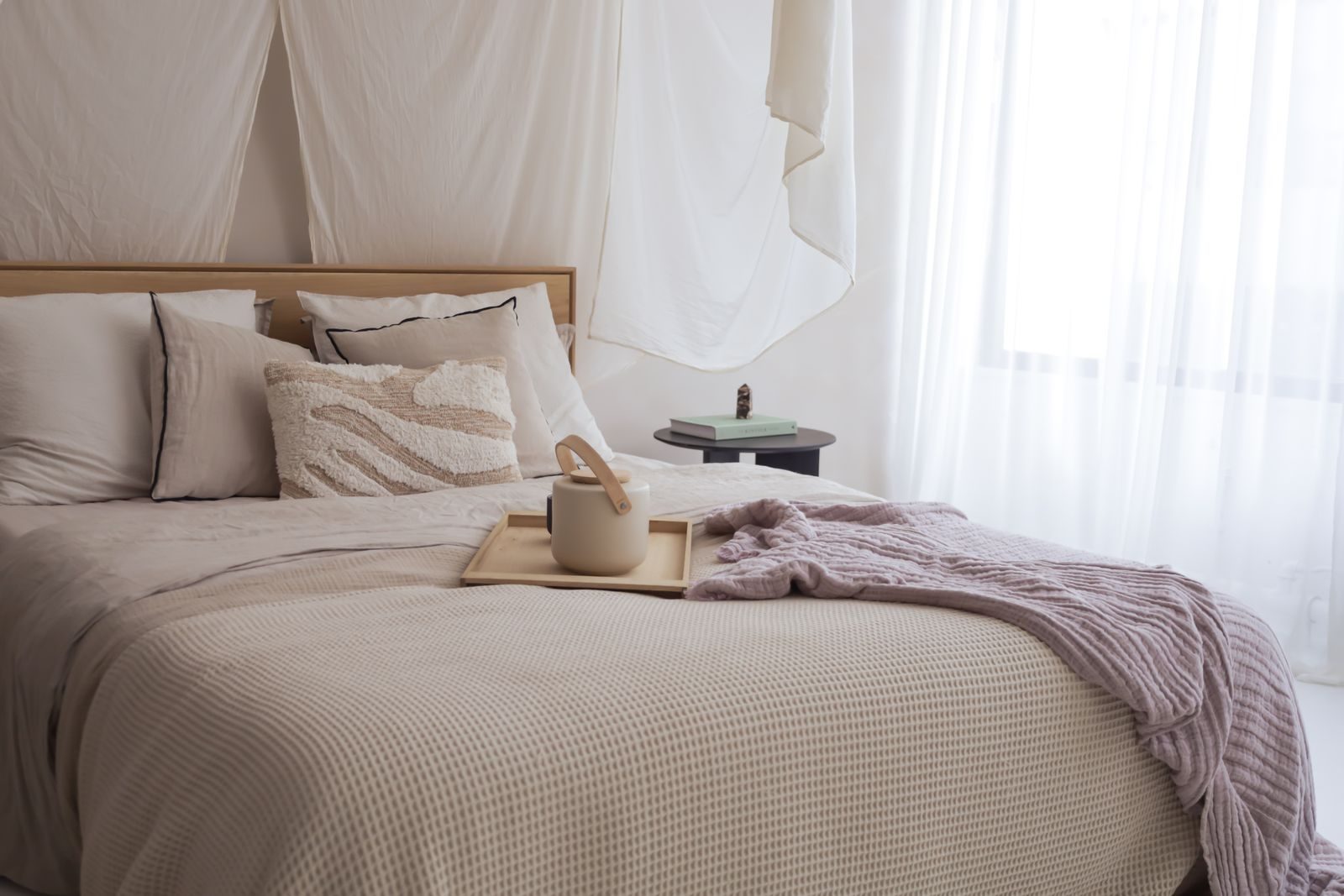 Linge de lit et jeté aux tons naturels dans une chambre lumineuse